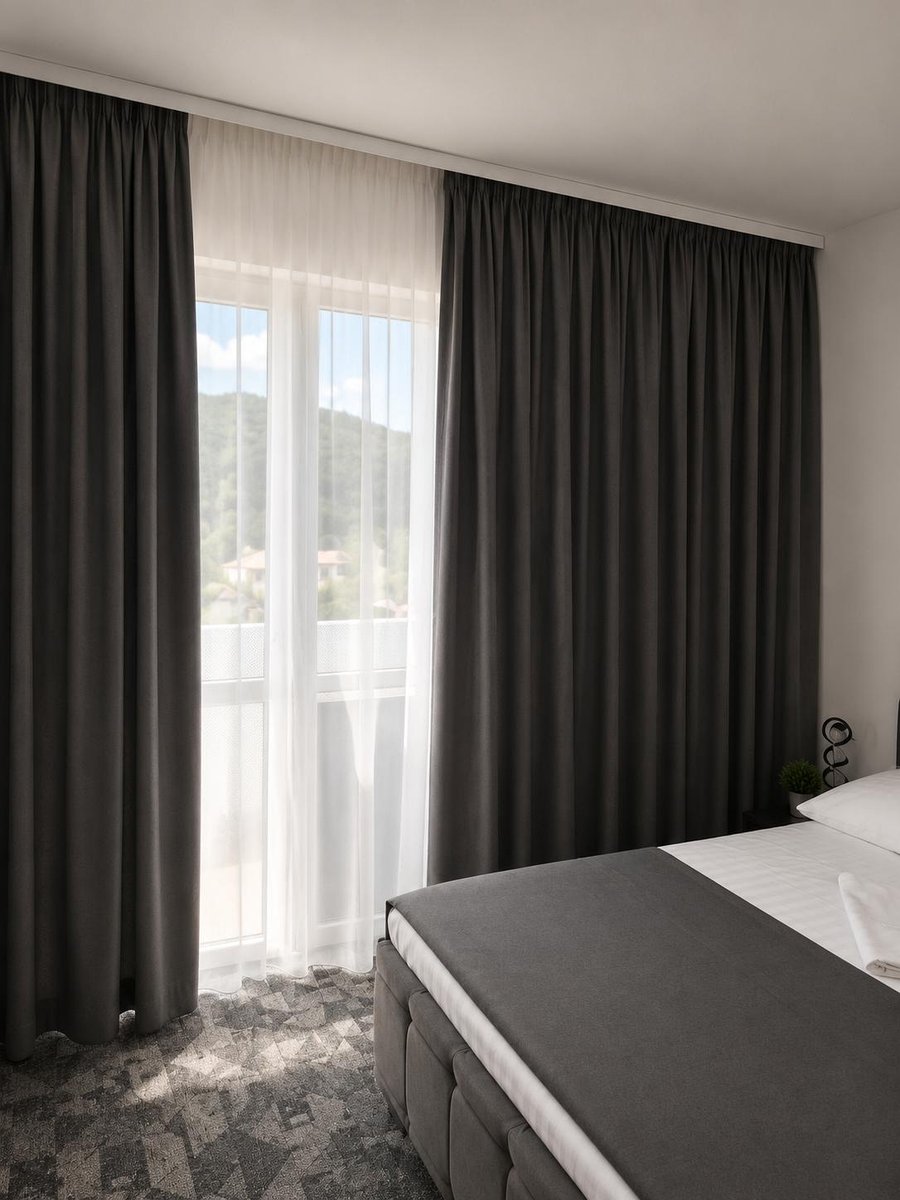 Cameră cu draperii gri și balcon